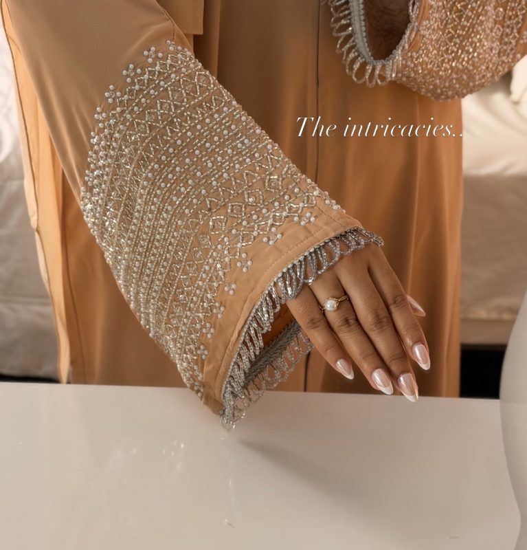 Cream luxury abaya with silver hand-embellished sleeves, elegant modest abaya in soft cream tone, formal Islamic dress for women, sophisticated Eid and occasion wear.