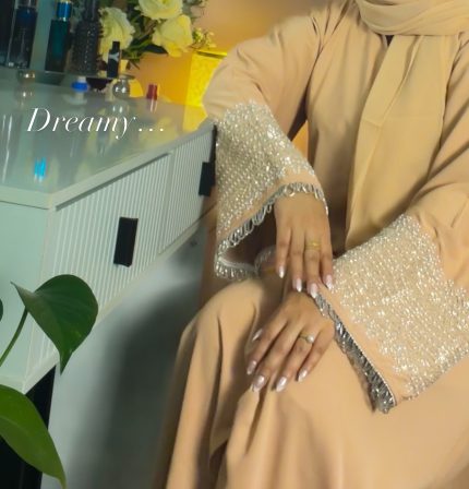 Cream luxury abaya with silver hand-embellished sleeves, elegant modest abaya in soft cream tone, formal Islamic dress for women, sophisticated Eid and occasion wear.