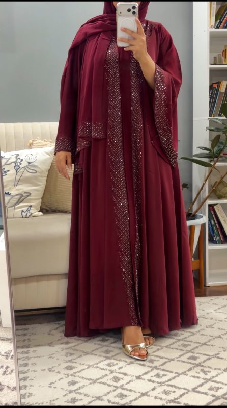 Elegant burgundy flare abaya featuring delicate crystal embellishments, flowing silhouette with wide flared cut, modest luxury evening abaya perfect for Eid, nikah, or formal occasions.